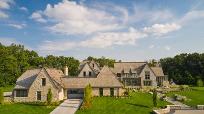 main exterior of stone country house with lawns